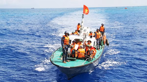 Ca-nô chở đại biểu Đoàn công tác số 19 từ tàu KN 491 vào đảo. Ảnh: THÁI THUẦN