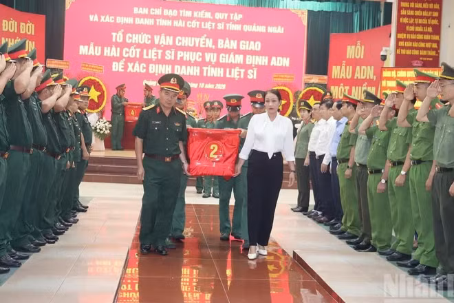 Các đại biểu thành kính, tiễn đưa mẫu sinh phẩm hài cốt các liệt sĩ bàn giao cho Viện Pháp y Quân đội phục vụ giám định ADN. (Ảnh: HIỂN CỪ)
