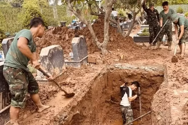 Các lực lượng thực hiện khai quật, lấy mẫu hài cốt liệt sĩ tại Nghĩa trang liệt sĩ Nhổn, phường Tây Tựu, Hà Nội. (Ảnh: MAI HOA)