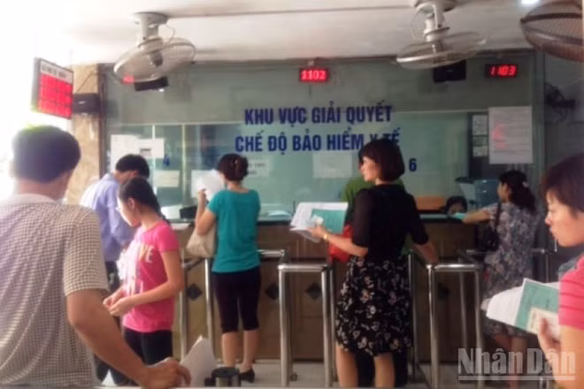 Người dân làm thủ tục đăng ký khám bệnh, chữa bệnh bảo hiểm y tế tại Bệnh viện. (Ảnh: ĐỖ THOA)