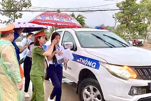 Lực lượng Cảnh sát giao thông Công an tỉnh Cà Mau sử dụng xe chuyên dụng chở các em học sinh đến điểm thi đúng giờ trong lúc trời mưa vào sáng 11/6.
