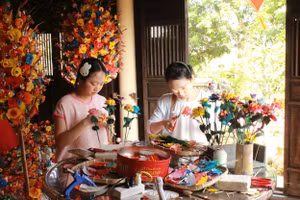 Du khách trải nghiệm tự làm hoa giấy.