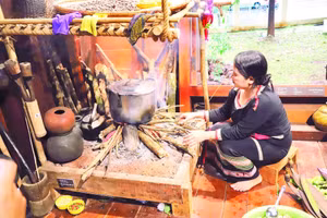 Người phụ nữ Ê Đê bên bếp lửa ở gian cuối ngôi nhà dài trong giờ nấu ăn cho gia đình.