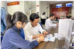 Hỗ trợ người dân làm thủ tục nộp hồ sơ trực tuyến tại Trung tâm phục vụ hành chính công Cần Thơ. Ảnh: MINH HUYỀN