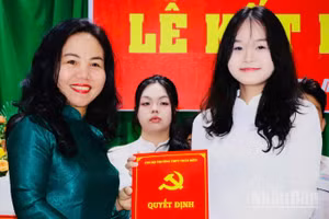Đồng chí Phạm Thị Thanh Hà, Bí thư Chi bộ, Hiệu trưởng Trường trung học phổ thông Trấn Biên trao quyết định kết nạp đảng viên cho học sinh.