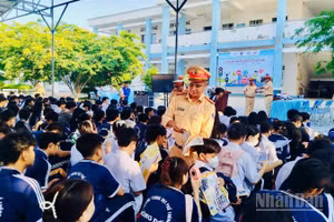 Cán bộ Phòng Cảnh sát giao thông Công an tỉnh Cà Mau phát tờ rơi tuyên truyền cho các em học sinh tại trường Trung học phổ thông Sông Đốc (xã Sông Đốc, tỉnh Cà Mau).