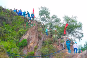 Hàng nghìn người chung sức tái tạo dòng chữ “Bác Hồ sống mãi” trên núi Nhón. (Ảnh: H.H)