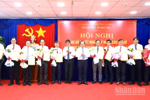 Phó Chủ tịch Ủy ban nhân dân tỉnh Cà Mau Nguyễn Minh Luân (thứ 6 từ phải qua) trao quyết định bổ nhiệm và tặng hoa các Hiệu trưởng Trường trung học phổ thông thuộc Sở Giáo dục và Đào tạo tỉnh. (Ảnh: HỮU TÙNG)
