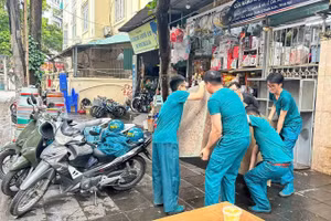 Lực lượng chức năng phường Thanh Xuân hỗ trợ người dân di chuyển đồ đạc đến nơi tạm cư.