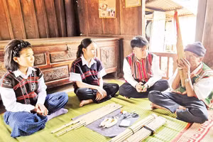 Nghệ nhân Hồ Văn Chôn (ngoài cùng bên phải) truyền dạy cách chế tác khèn bè cho thanh niên trong xã.