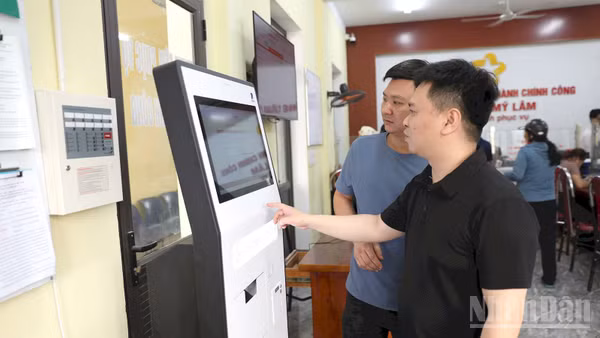 Người dân lấy số thứ tự thực hiện thủ tục hành chính tại ki-ốt tự động tại Trung tâm Hành chính công phường Mỹ Lâm. (Ảnh: Đức Thắng)