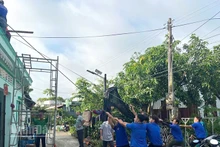 Chính quyền địa phương xã Tân Khánh Trung cùng bà con dọn dẹp, khắc phục hậu quả sau dông lốc, mưa lớn.