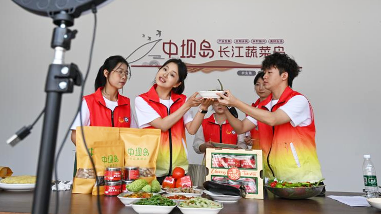 Sinh viên tình nguyện của Học viện Tài chính-Kinh tế Trùng Khánh, Trung Quốc live stream giới thiệu sản phẩm địa phương. (Ảnh: Tân Hoa Xã)
