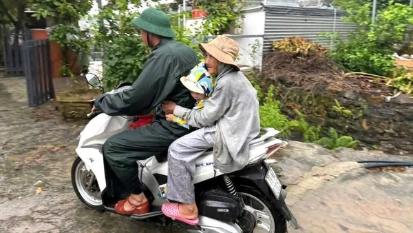 Chiến sĩ Đồn Biên phòng cửa khẩu cảng Nha Trang cơ động đưa người dân đến nơi an toàn. (Ảnh: Văn Tân).