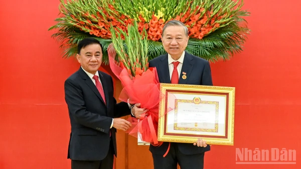 Thường trực Ban Bí thư Trần Cẩm Tú trao huy hiệu 45 năm tuổi đảng, tặng hoa chúc mừng đồng chí Tô Lâm, Tổng Bí thư Ban Chấp hành Trung ương Đảng Cộng sản Việt Nam. (Ảnh: DUY LINH)
