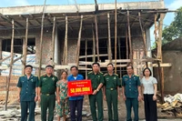 Cựu chiến binh Phạm Văn Lượng (đứng giữa) nhận hỗ trợ xây nhà mới. (Ảnh NGỌC LAN)
