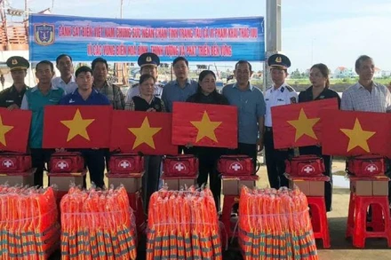 Đại biểu tham dự hội nghị tặng cờ Tổ quốc, áo phao, thiết bị y tế cho ngư dân. (Ảnh: HOÀNG TRUNG)