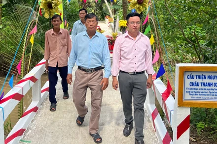 Nguyễn Văn Bé Tư (phải) vận động nhà hảo tâm xây cầu nhờ mạng xã hội. (Ảnh: HOÀNG TRUNG)