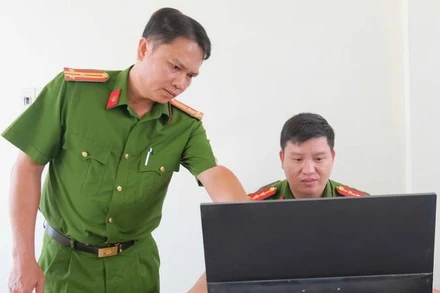 Thượng tá Cao Thành Nhân (trái) hướng dẫn cán bộ hoàn chỉnh hồ sơ quản lý địa bàn. (Ảnh: Đăng Khoa)