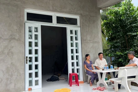 Gia đình bà Duyên vui mừng bên căn nhà mới vừa được hỗ trợ xây dựng. (Ảnh: HOÀNG TRUNG)