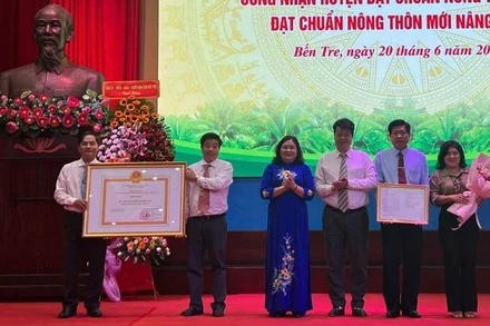 Lãnh đạo dự hội nghị trao quyết định của Thủ tướng Chính phủ công nhận huyện Chợ Lách đạt chuẩn nông thôn mới nâng cao. (Ảnh: HOÀNG TRUNG)