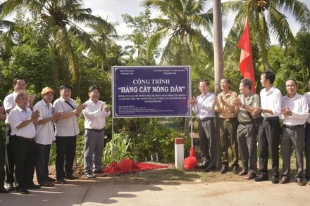 Lãnh đạo tỉnh Bến Tre cùng người dân thực hiện trồng cây xanh bảo vệ môi trường. (Ảnh: HOÀNG TRUNG).