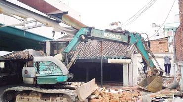 Lực lượng chức năng tháo dỡ công trình xây dựng trái phép tại phường Bình Thạnh. (Ảnh THẾ ANH)