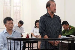 Hai bị cáo Nguyễn Đình Bang và Nguyễn Huy Khang tại một phiên sơ thẩm. (Ảnh: LÊ NHUNG)