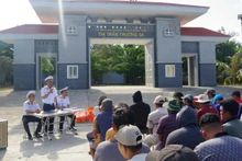 Cán bộ Trung tâm Dịch vụ hậu cần kỹ thuật Trường Sa tuyên truyền, phổ biến cho ngư dân về Chỉ thị 45 và về hoạt động của các âu tàu, làng chài trên quần đảo Trường Sa. (Ảnh: Đức Thuận)