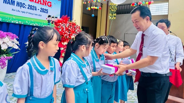 Thầy Trần Văn Sơn, Hiệu trưởng Trường Tiểu học Kim Đồng (thành phố Bạc Liêu) trao phần thưởng các em học sinh xuất sắc, năm học 2024-2025. (Ảnh: TRỌNG DUY)