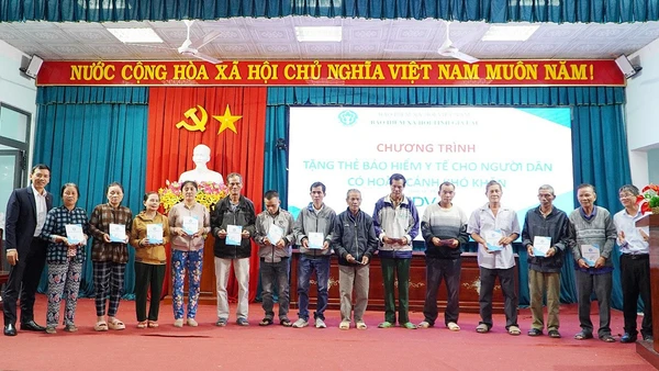 Phó Giám đốc Bảo hiểm xã hội tỉnh Trần Ngọc Tuấn cùng các đại biểu trao tặng thẻ bảo hiểm y tế cho người dân