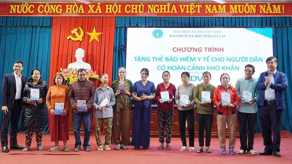 Phó Giám đốc Bảo hiểm xã hội tỉnh Trần Ngọc Tuấn cùng các đại biểu trao tặng thẻ bảo hiểm y tế cho người dân. (Ảnh: BTC)