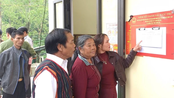 Cử tri bản Hôi Rấy, xã Trường Sơn (khu vực bỏ phiếu số 16) xem danh sách cử tri tại nhà văn hóa bản.