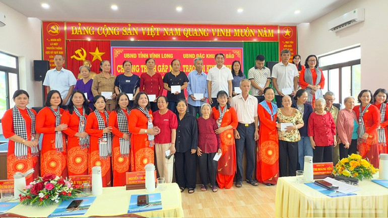 Đoàn đại biểu nữ cán bộ tỉnh Vĩnh Long chụp ảnh lưu niệm với gia đình chính sách đặc khu Côn Đảo. ndo_br_anh-4-chup-hinh-luu-niem.jpg