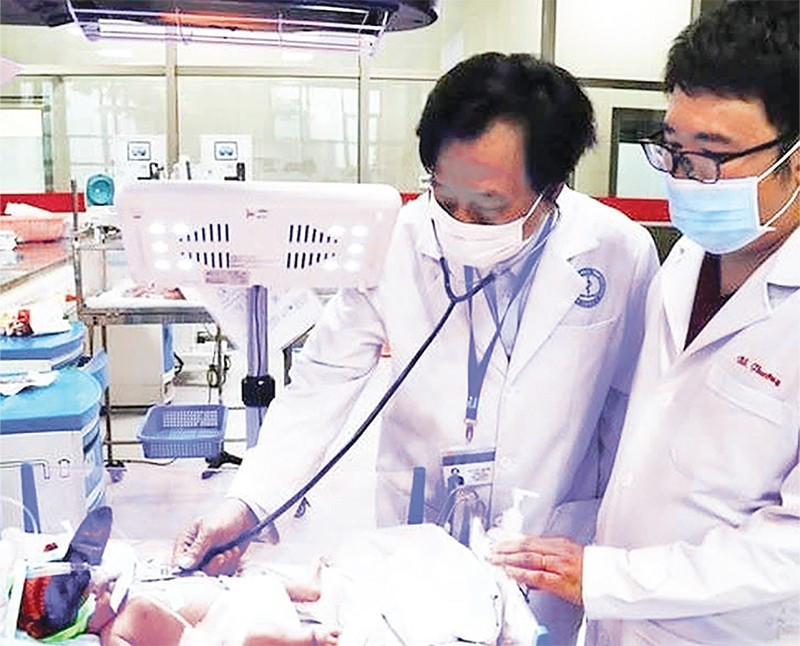 Giáo sư, Tiến sĩ, Thầy thuốc Nhân dân, Anh hùng Lao động thời kỳ đổi mới Tạ Văn Trầm (bên trái) khám bệnh cho bệnh nhi.