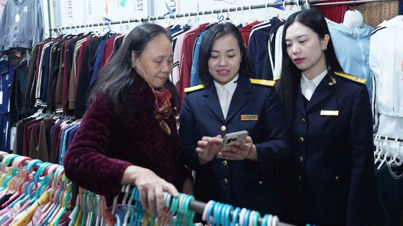 Cán bộ Thuế thành phố Hà Nội hướng dẫn hộ kinh doanh thực hiện thủ tục kê khai thuế.