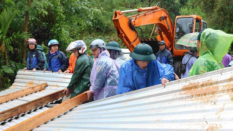 Các lực lượng thu dọn tại khu vực sạt lở.