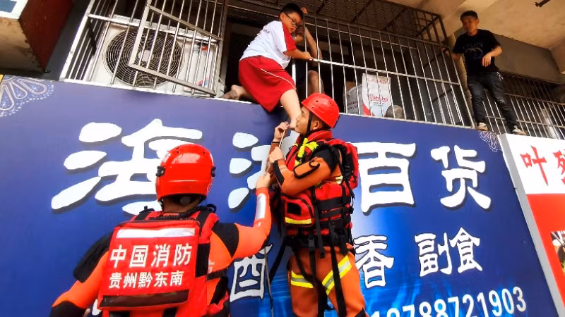 Lực lượng cứu hộ sơ tán người dân khỏi khu vực ngập lụt ở huyện Dong Giang, Tỉnh Quý Châu, Trung Quốc. (Ảnh: THX/TTXVN)