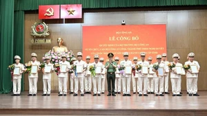 Bộ trưởng Lương Tam Quang trao Quyết định và tặng hoa chúc mừng các đồng chí Giám đốc Công an địa phương sau sáp nhập.