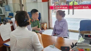 Cán bộ công an và nhân viên ngân hàng giải thích cho bà T. về thủ đoạn của các đối tượng lừa đảo. Ảnh: ANTĐ