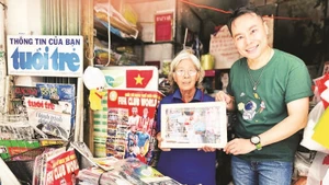 Nhà báo Trung Nghĩa tặng quà lưu niệm cho chủ sạp báo giấy lâu năm ở Thành phố Hồ Chí Minh. (Ảnh CTV)
