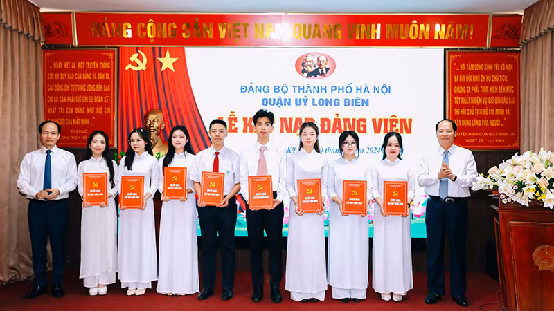 Trưởng Ban Tuyên giáo Thành ủy Hà Nội Nguyễn Doãn Toản và Bí thư Quận ủy Long Biên Đường Hoài Nam trao Quyết định kết nạp đảng viên.