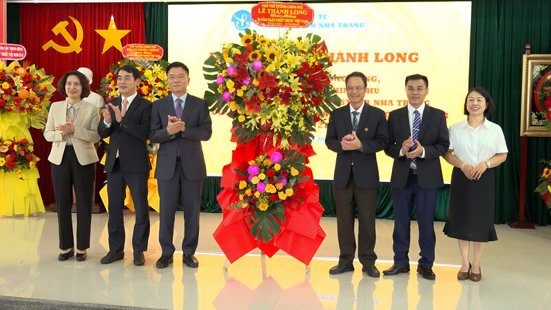 Phó Thủ tướng Chính phủ Lê Thành Long (thứ 3 từ trái qua) tặng hoa lãnh đạo Viện Pasteur Nha Trang. (Ảnh: NGỌC HÒA)