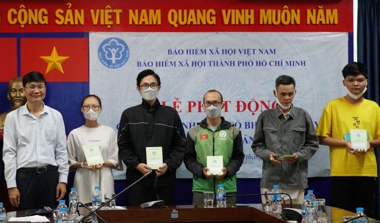 Trao thẻ bảo hiểm y tế, sổ bảo hiểm xã hội cho người dân có hoàn cảnh khó khăn, diện chính sách trên địa bàn Thành phố Hồ Chí Minh. (Ảnh: HSS)