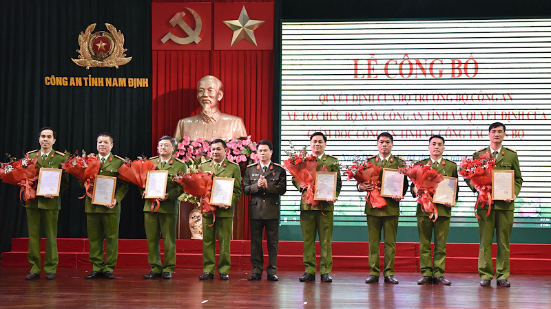 Đại tá Nguyễn Hữu Mạnh, Giám đốc Công an tỉnh Nam Định trao quyết định, tặng hoa chúc mừng các đồng chí nhận công tác mới. 