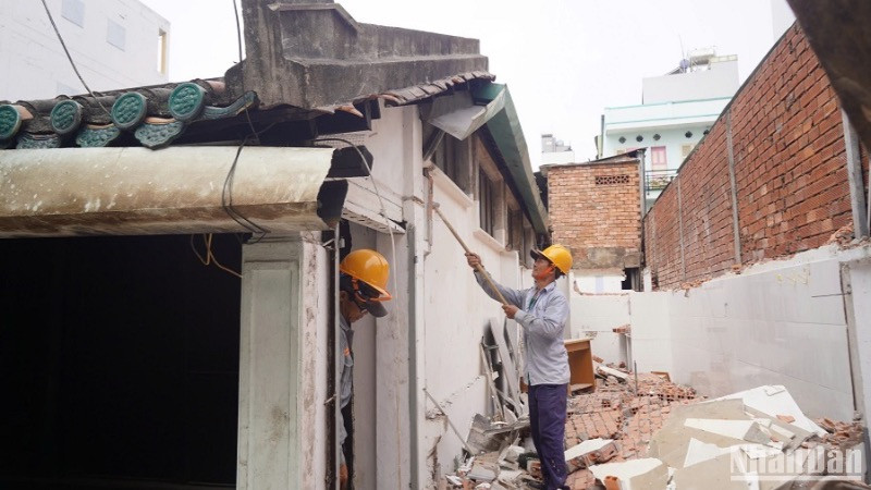 Các công nhân tháo dỡ hạng mục vi phạm xây dựng tại Nhà cổ dân dụng Vương Hồng Sến. (Ảnh: THẾ ANH)