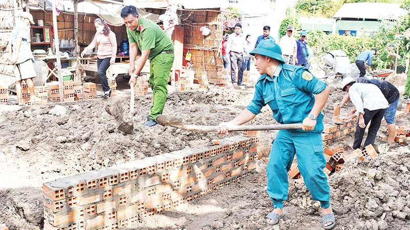 Lực lượng vũ trang cùng các đoàn thể chính trị xã Huyền Hội, huyện Càng Long, tỉnh Trà Vinh, hỗ trợ người dân xây nhà. (Ảnh: KHỞI - GIANG)