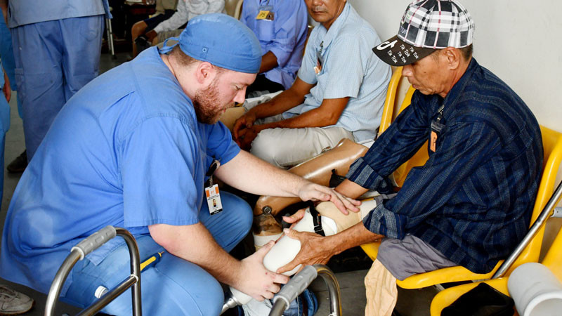 Thành viên Đoàn thiện nguyện Mercer On Mission lắp chân giả cho người khuyết tật.