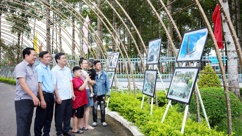 Người dân và chính quyền địa phương tham quan triển lãm ảnh. (Ảnh: HUỲNH LÃNH).