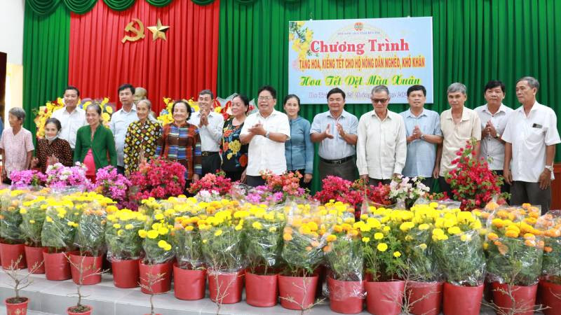 Lãnh đạo Hội Nông dân tỉnh Bến Tre cùng chính quyền địa phương trao hoa, cây kiểng cho hội viên, nông dân có hoàn cảnh khó khăn tại huyện Ba Tri. (Ảnh: HOÀNG TRUNG)